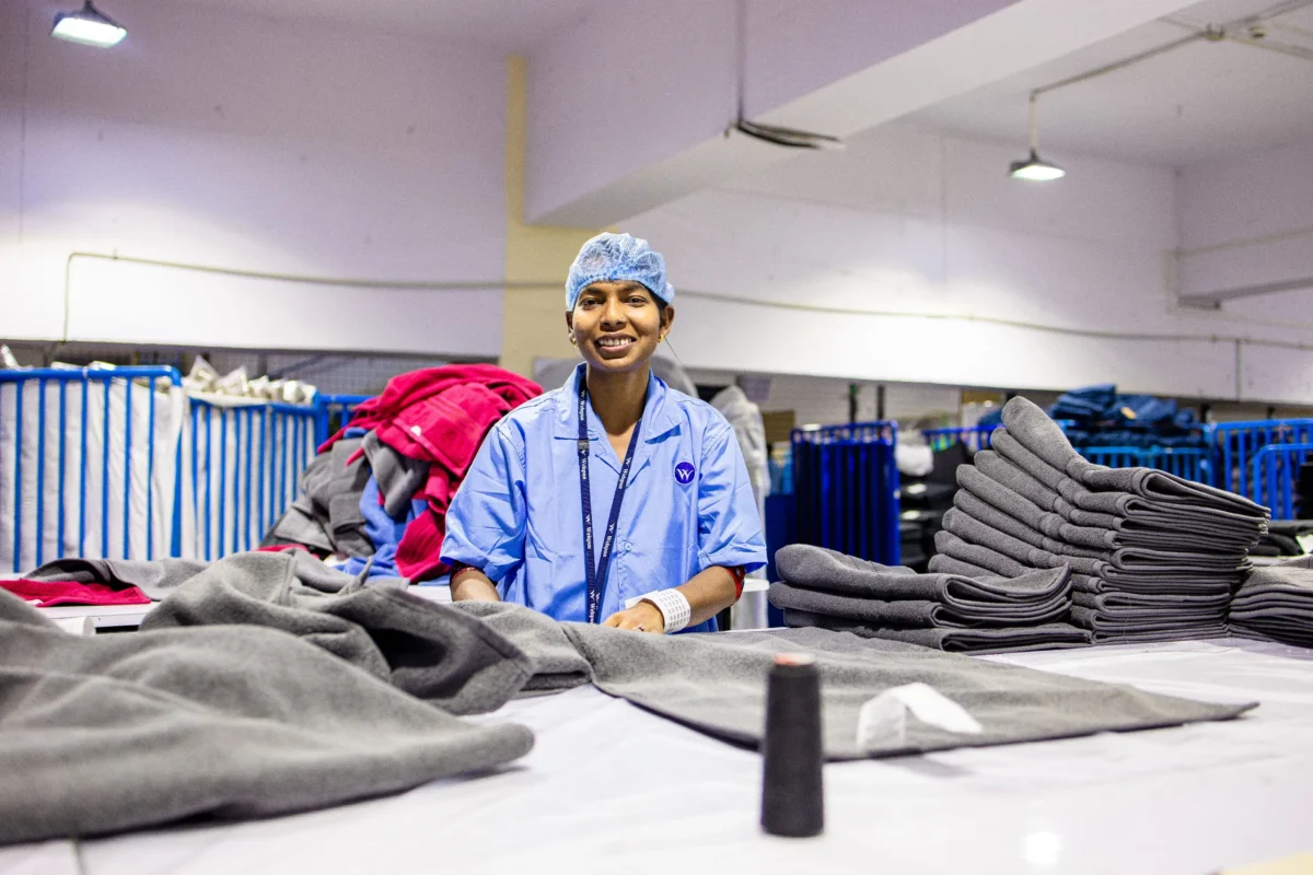 worker in sewing factory smiles into the camera
